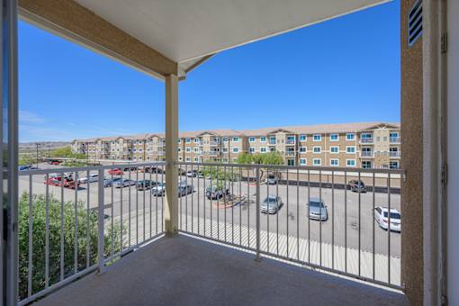 A balcony view of a parking lot and apartment buildings at VISTA CREEK Apartments, Nevada