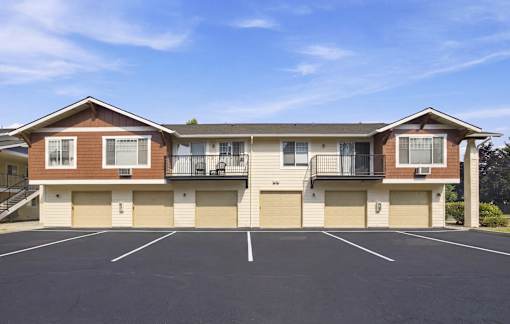 A large apartment complex with a parking lot in front.