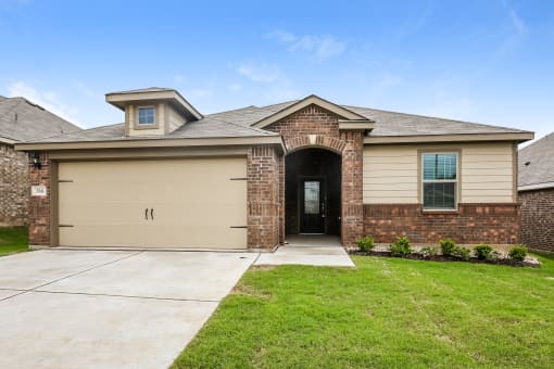 A house with a garage door and a brick wall.