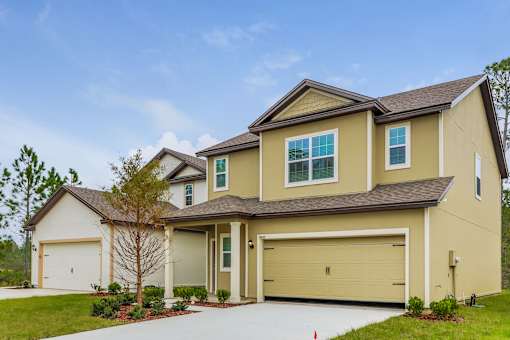 A two-story house with a garage and a driveway.