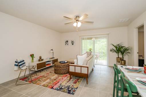 A living room with a white couch, a rug, and a ceiling fan.