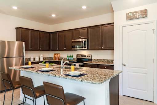 A kitchen with brown cabinets and a granite countertop.