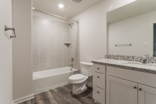 a bathroom with a toilet and a tub and a sink