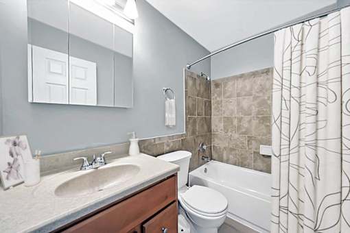 A bathroom with a sink, toilet, and bathtub.