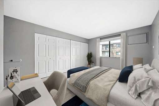A bedroom with a bed, chair, and desk.