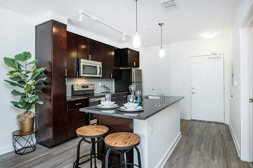 A kitchen with dark brown cabinets and a white countertop.