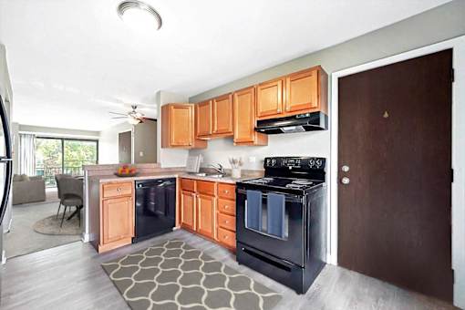 A modern kitchen with wooden cabinets and black appliances.