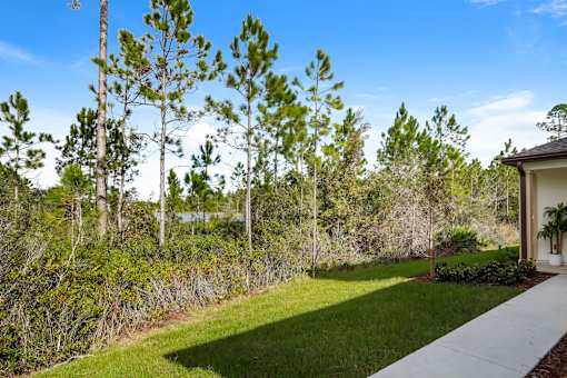 A house with a white pathway leading to it and a green lawn in front.