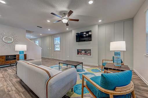 a living room with a fireplace and a ceiling fan