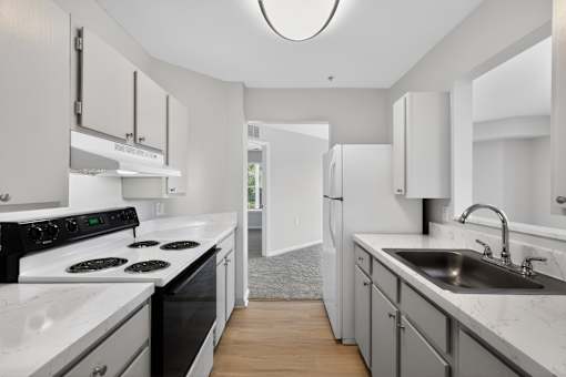 A modern kitchen with white appliances and cabinets.