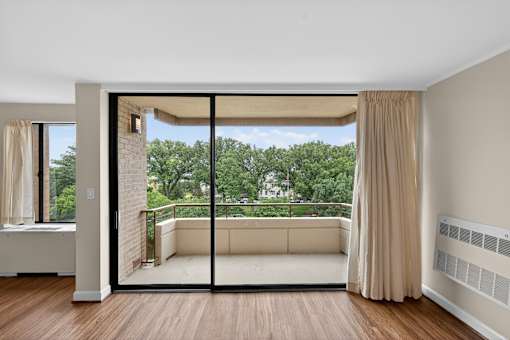 A room with a sliding glass door leading to a balcony.