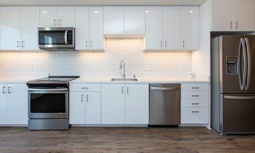 A modern kitchen with white cabinets and stainless steel appliances.
