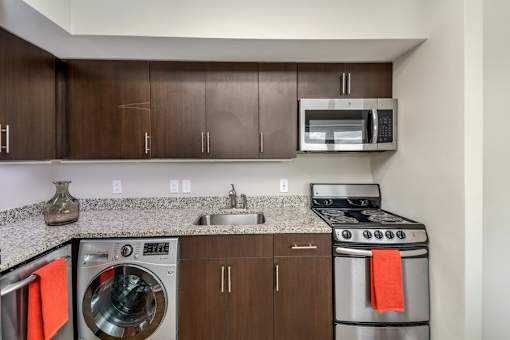 A modern kitchen with a washer and dryer built into the cabinetry.