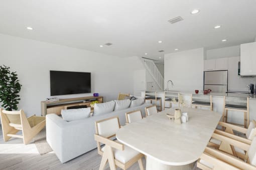 a living room and dining room with a table and chairs