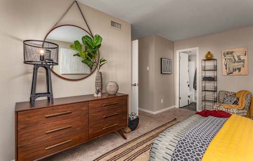 A bedroom with a bed, dresser, and mirror.