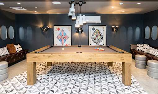 A pool table in a room with a black and white tiled floor.