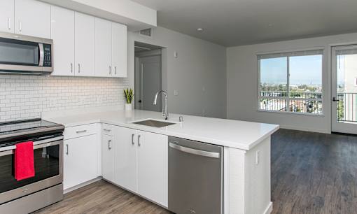 A kitchen with white cabinets and a black stove top oven.