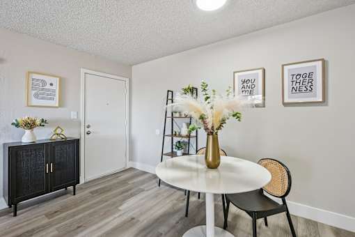 A dining room with a white table and chairs.