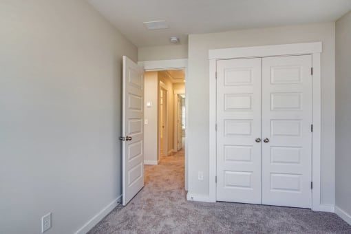 a bedroom with two closets and a hallway leading to a closet