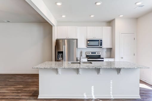 a kitchen with white cabinets and a granite counter top