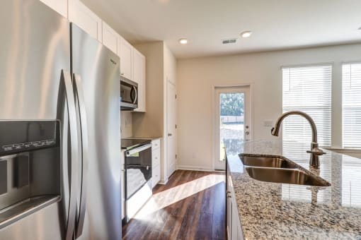 Townhomes Near The Citadel - Highland Townhomes - Kitchen With Stainless Steel Appliances, Granite Countertops, Plenty Of Storage, Pantry, And Kitchen Island
