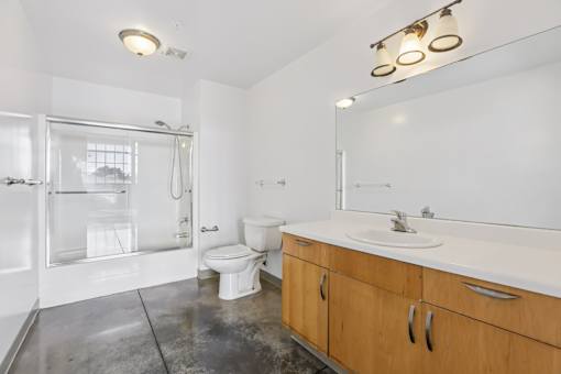 A bathroom with a toilet, sink, and shower.