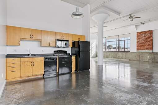 A kitchen with black appliances and wooden cabinets.