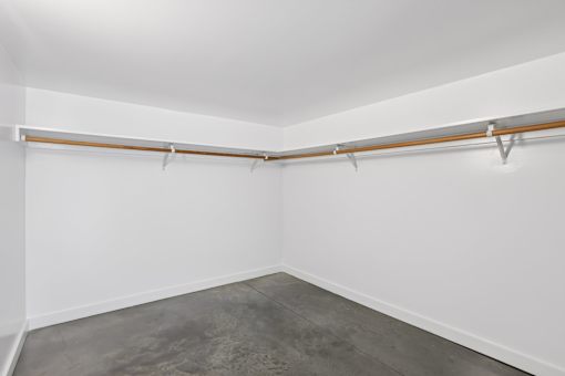 A room with a white wall and a grey floor.