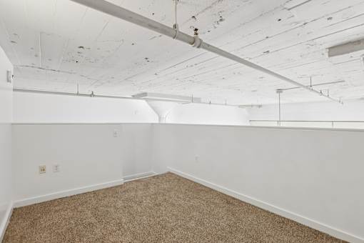 A room with white walls and a carpeted floor.
