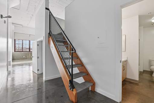 A staircase with a metal railing and wooden steps.