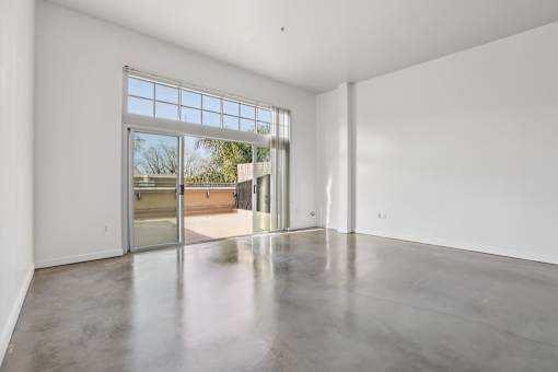 A large empty room with a sliding glass door.