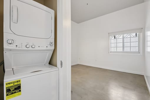 A white oven with a sticker on it is in a room with a window.