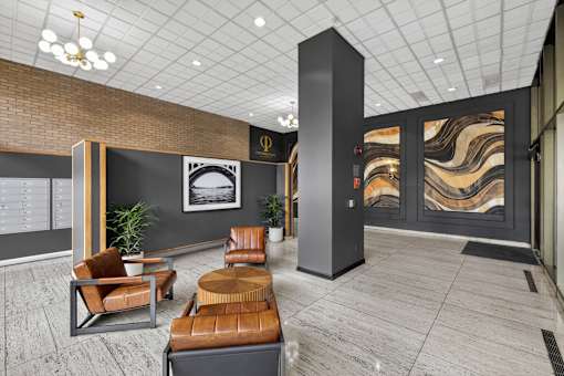 A modern waiting area with brown leather chairs and a marble wall.