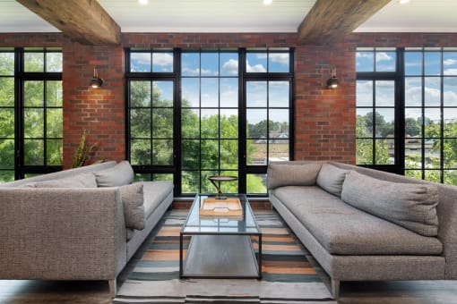 a living room with couches and a coffee table in front of windows