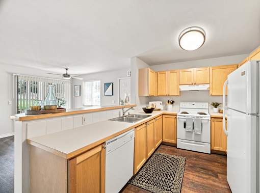 A kitchen with wooden cabinets and white appliances.