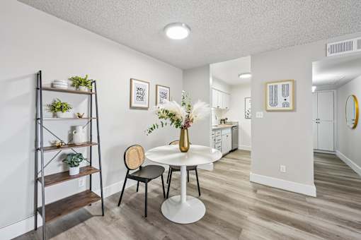 A dining room with a white table and chairs.