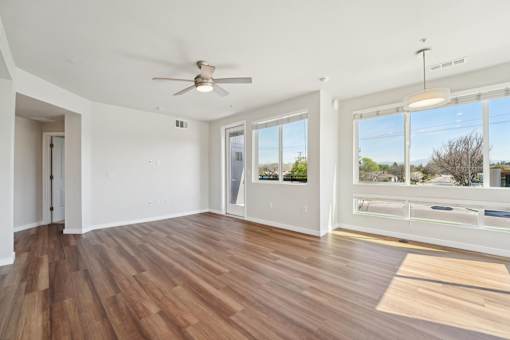Spacious open-concept apartment living area with large windows at Santana Terrace in Santa Clara, CA