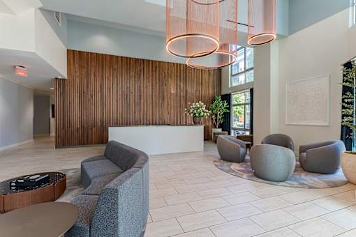 A reception area with grey couches and a wooden reception desk.