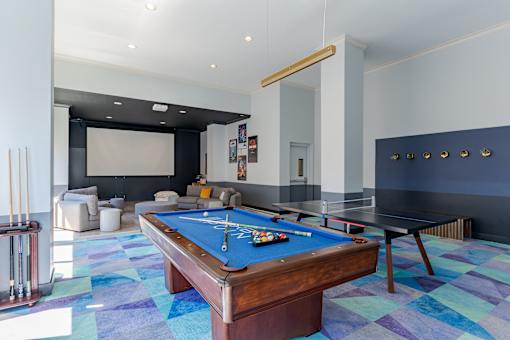 A pool table is in the middle of a room with a blue carpet.