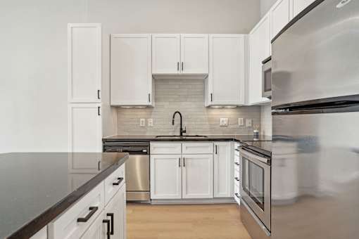 A kitchen with white cabinets and stainless steel appliances.