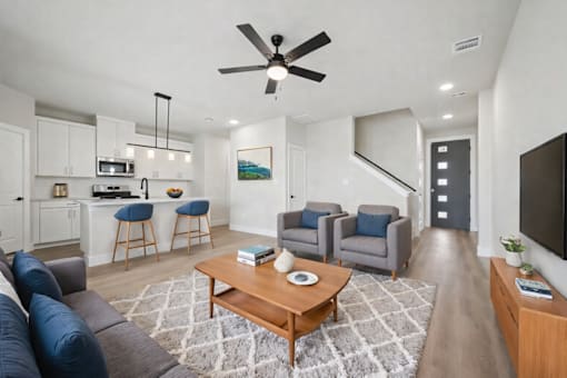 A living room with a couch, chairs, and a coffee table.