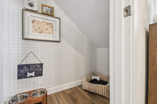 A dog's room with a chalkboard sign that says "bone appetit" and a dog bed.