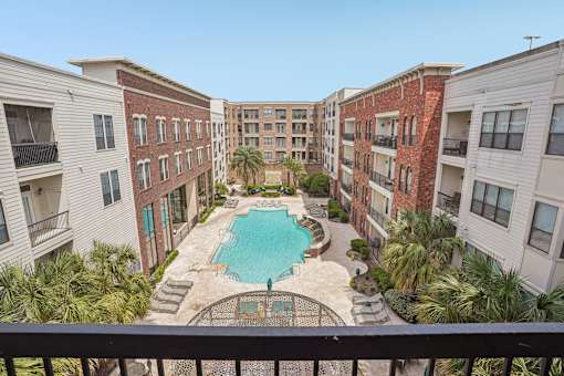 A view of a pool from a balcony of a building.