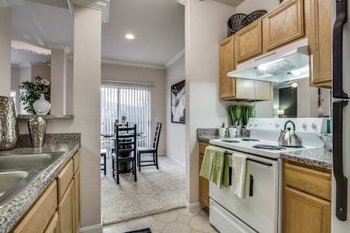 an open kitchen and dining room with white appliances and wood cabinets