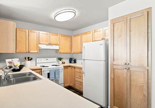 A kitchen with wooden cabinets and a white refrigerator.