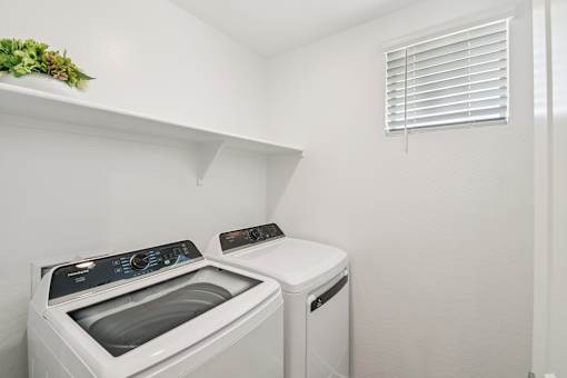 A small laundry room with a washer and dryer.