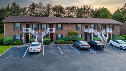 an apartment building with cars parked in front of it