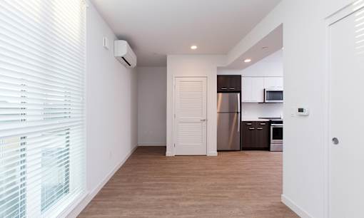 A kitchen area with a refrigerator, microwave, and cabinets.