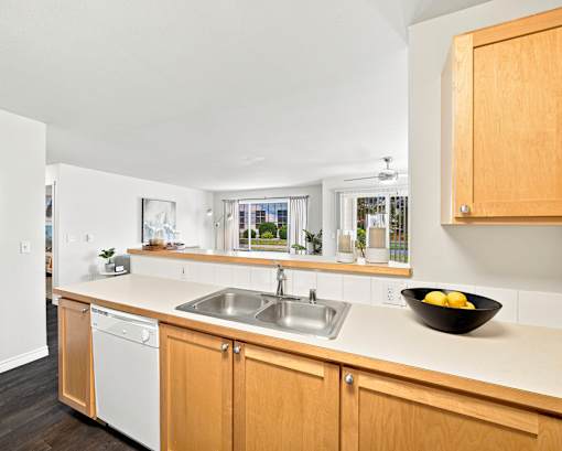 A kitchen with wooden cabinets and a white dishwasher.