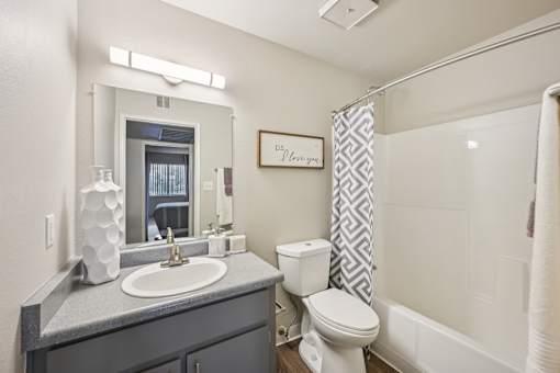 A bathroom with a toilet, sink, and shower.